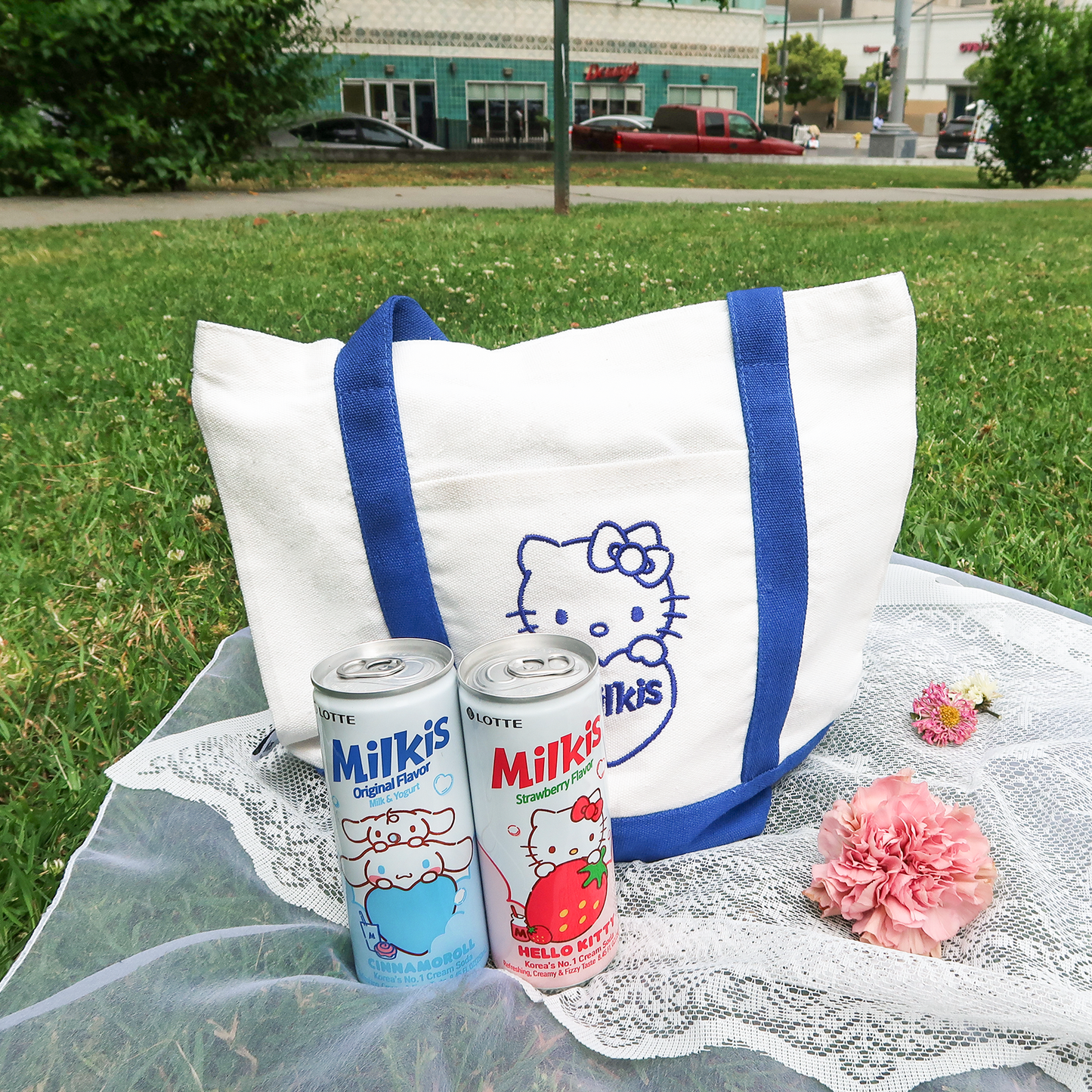 Sanrio x Milkis collaboration eco- bag on the grass. It's Original and straberry flavor Milkis cans.