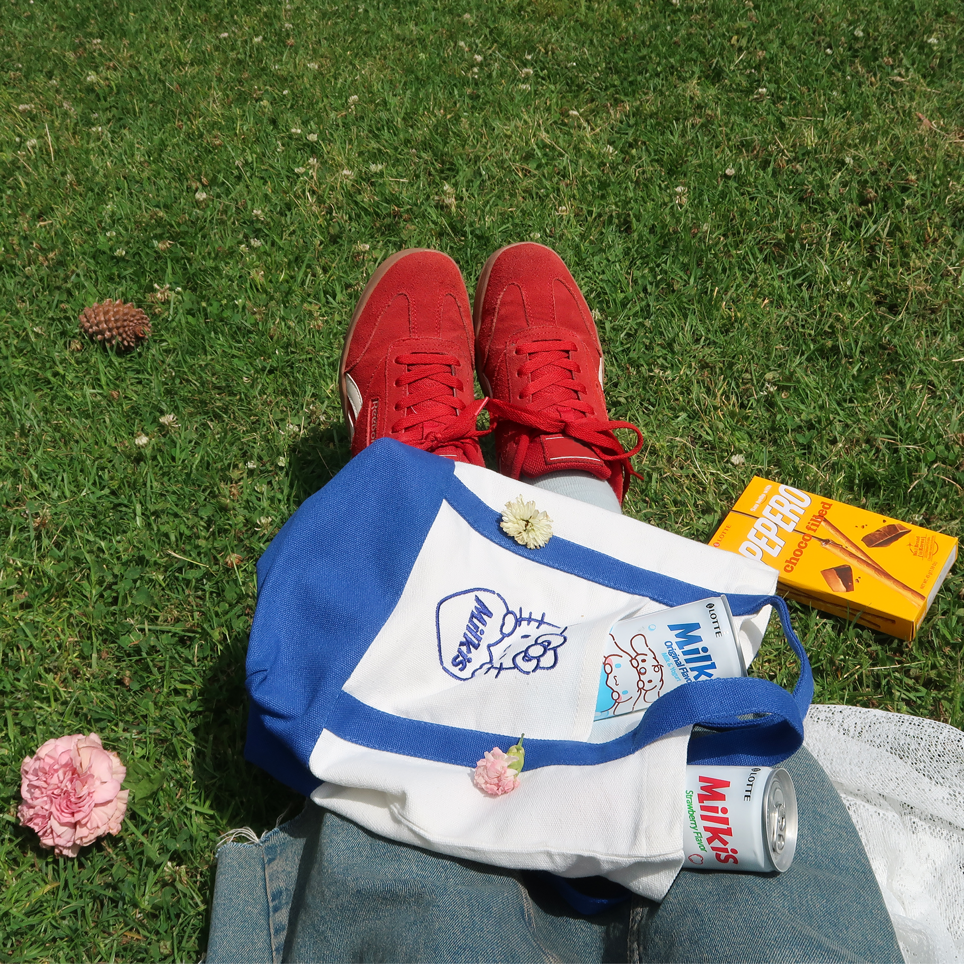 Sanrio x Milkis collaboration eco- bag on the grass. It's Original and straberry flavor Milkis cans.